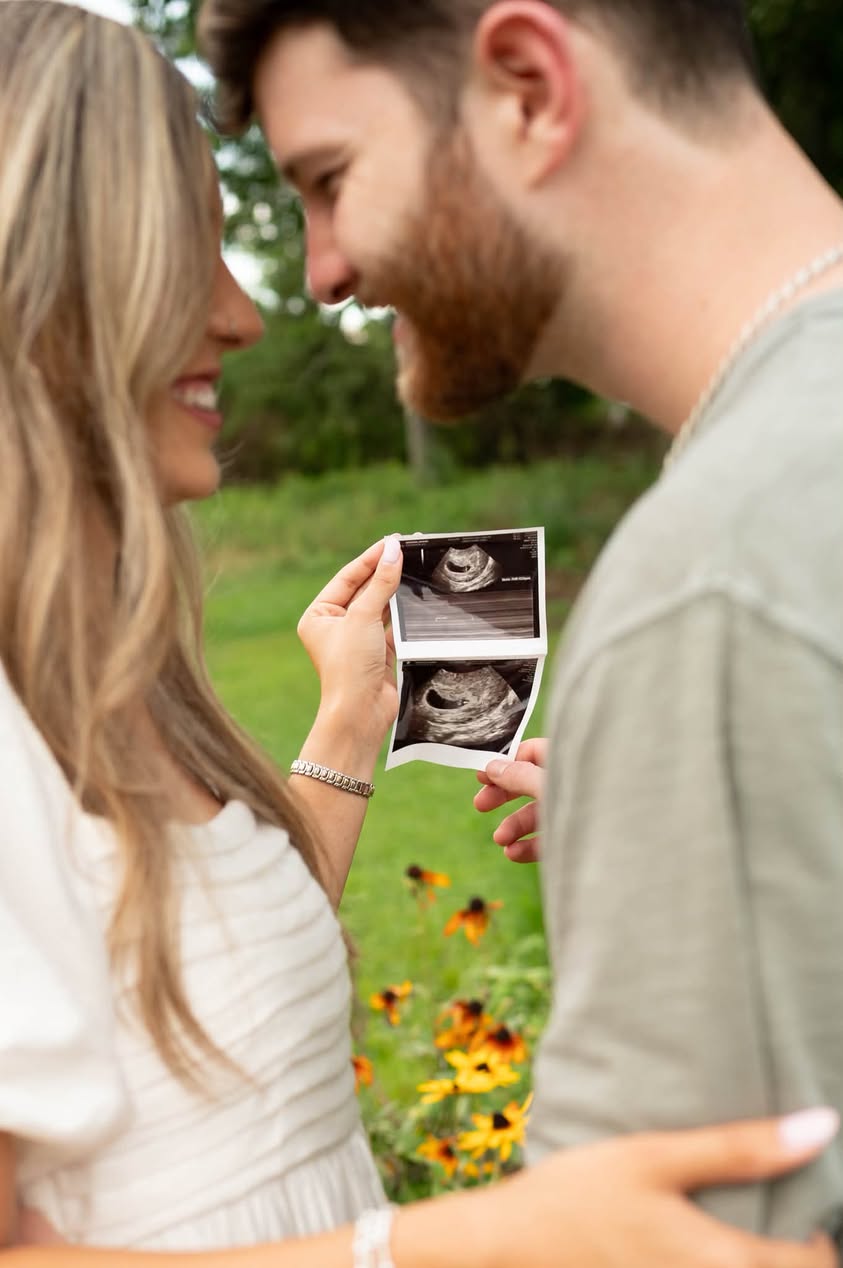 Expecting couple holding their ultrasound photographs together
